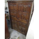 A 1930s oak Gothic style cabinet with four linenfold carved doors, on extended stile feet 180cm h