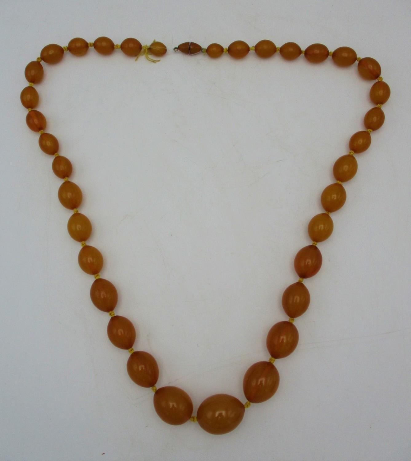 A yellow Bakelite necklace with thirty five graduated beads and a screw clasp, 109g, 81.5cm l