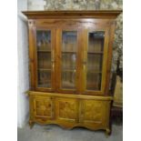 A modern Italian walnut finished bookcase cabinet with three glazed doors and three carved