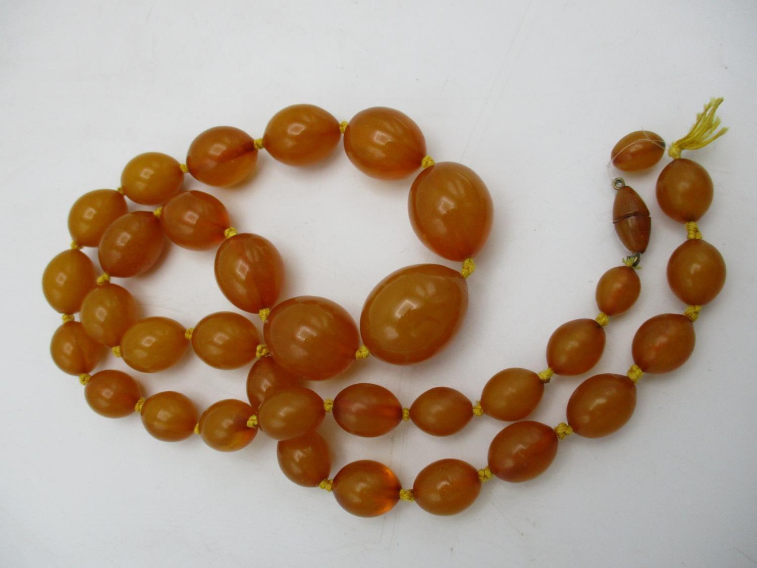 A yellow Bakelite necklace with thirty five graduated beads and a screw clasp, 109g, 81.5cm l - Image 3 of 4