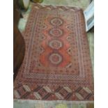 A Bokhara red ground rug having multi-guard borders and tasselled ends, 203cm x 121cm