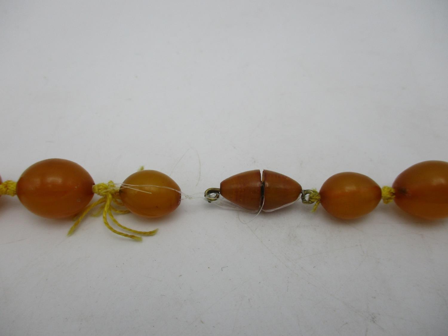 A yellow Bakelite necklace with thirty five graduated beads and a screw clasp, 109g, 81.5cm l - Image 4 of 4