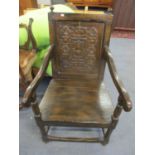 A 20th century oak Wainscot armchair having a carved back panel