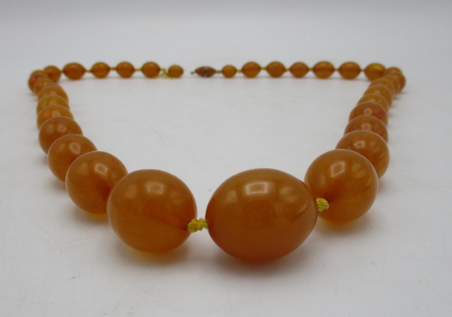 A yellow Bakelite necklace with thirty five graduated beads and a screw clasp, 109g, 81.5cm l - Image 2 of 4