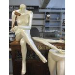 A cream pearlescent female mannequin with extra parts to create a seated or standing mannequin