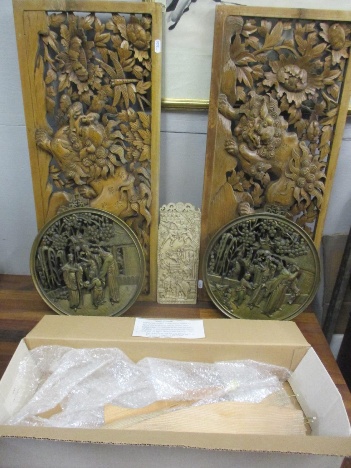 Teak oriental panels together with a small plaque and round oriental panels