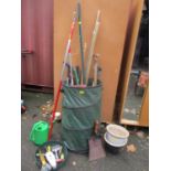 A mixed lot of tools to include a shovel, rake, watering can and other items