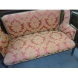 An Edwardian mahogany upholstered two-seater sofa on turned and fluted legs