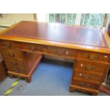 A reproduction yew twin pedestal desk with red leather scriber