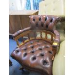 A reproduction yew swivel desk chair with brown leather upholstery