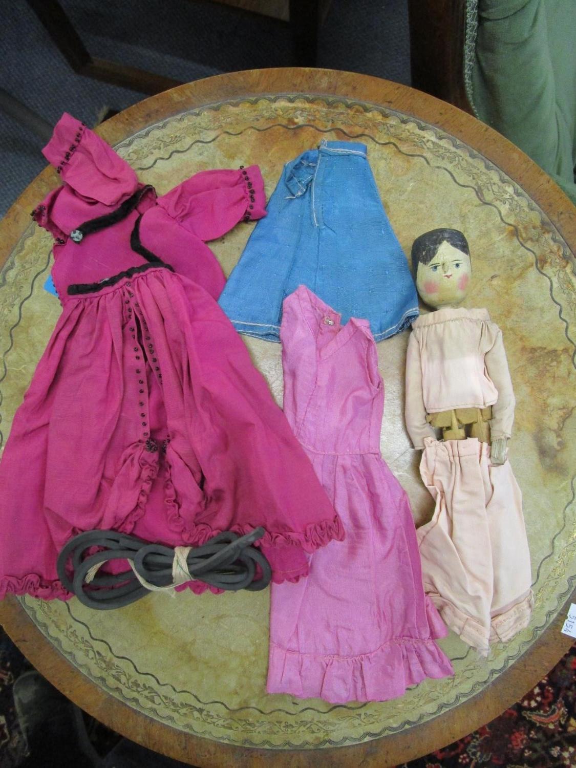 A 19th century Grodnertal wooden peg doll with dresses and undergarments