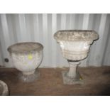 Two weathered concrete garden footed planters