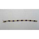 A 9ct gold and amethyst bracelet, with pierced scroll detail to the gold parts set with eight