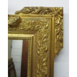 A late 19th/early 20th century gilt gesso mirror, in the Louis XVI style, modelled with scrolled