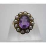 A 9ct gold ring set with an oval cut amethyst surrounded by pearls, in heart shaped box, 3.5 g, size