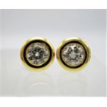 A pair of gold coloured stud earring, each set with a 0.3ct diamond approximately, in a rub-over