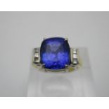 A tanzanite and diamond ring, modelled with a central large cushion cut tanzanite flanked with three
