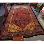 A hand woven Bidjar carpet with palmettes, flower heads and other foliate motifs on a red ground