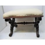 A Victorian mahogany x frame stool, the shaped top upholstered with a cream coloured fabric, on