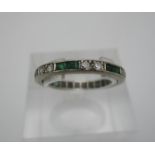 A pave set diamond and emerald eternity ring, set in white metal, unmarked, size S, 3.3 g