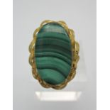 An 18ct gold and malachite ring, designed with textured gold edge and a central oval malachite