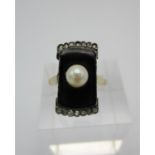 An Art Deco style diamond, enamel and pearl tablet ring, with central cultured pearl on a black