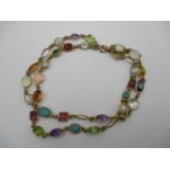 A 15ct gold and multi gem double strand bracelet, set with moonstones, peridot, opals, topaz,
