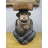 A modern hardwood stool fashioned as two monkeys