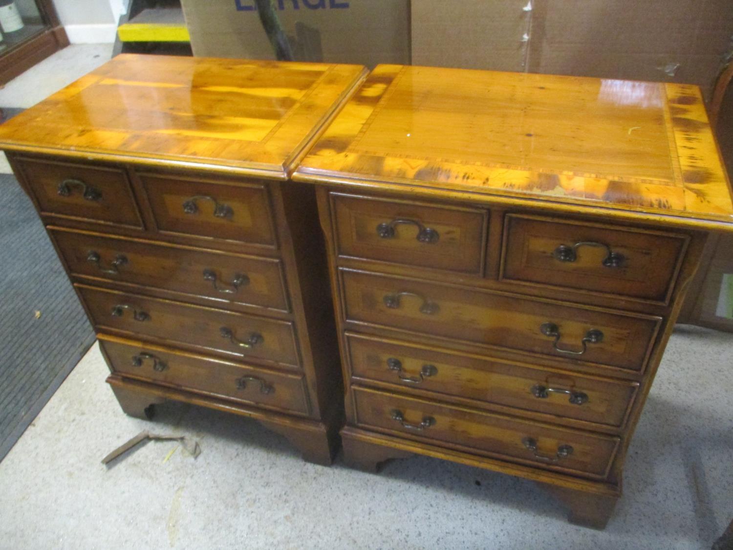 A pair of late 20th century yew five drawer bedside chests, on bracket feet, 82 h x 47cm w