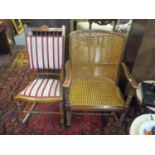 An Edwardian rocking chair with upholstered seat and back on turned front legs and front