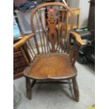 An elm and beech Windsor wheel back armchair on ring turned legs united by elliptical double H-