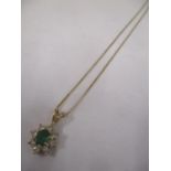 A gold coloured necklace stamped 585 with an emerald and diamond pendant