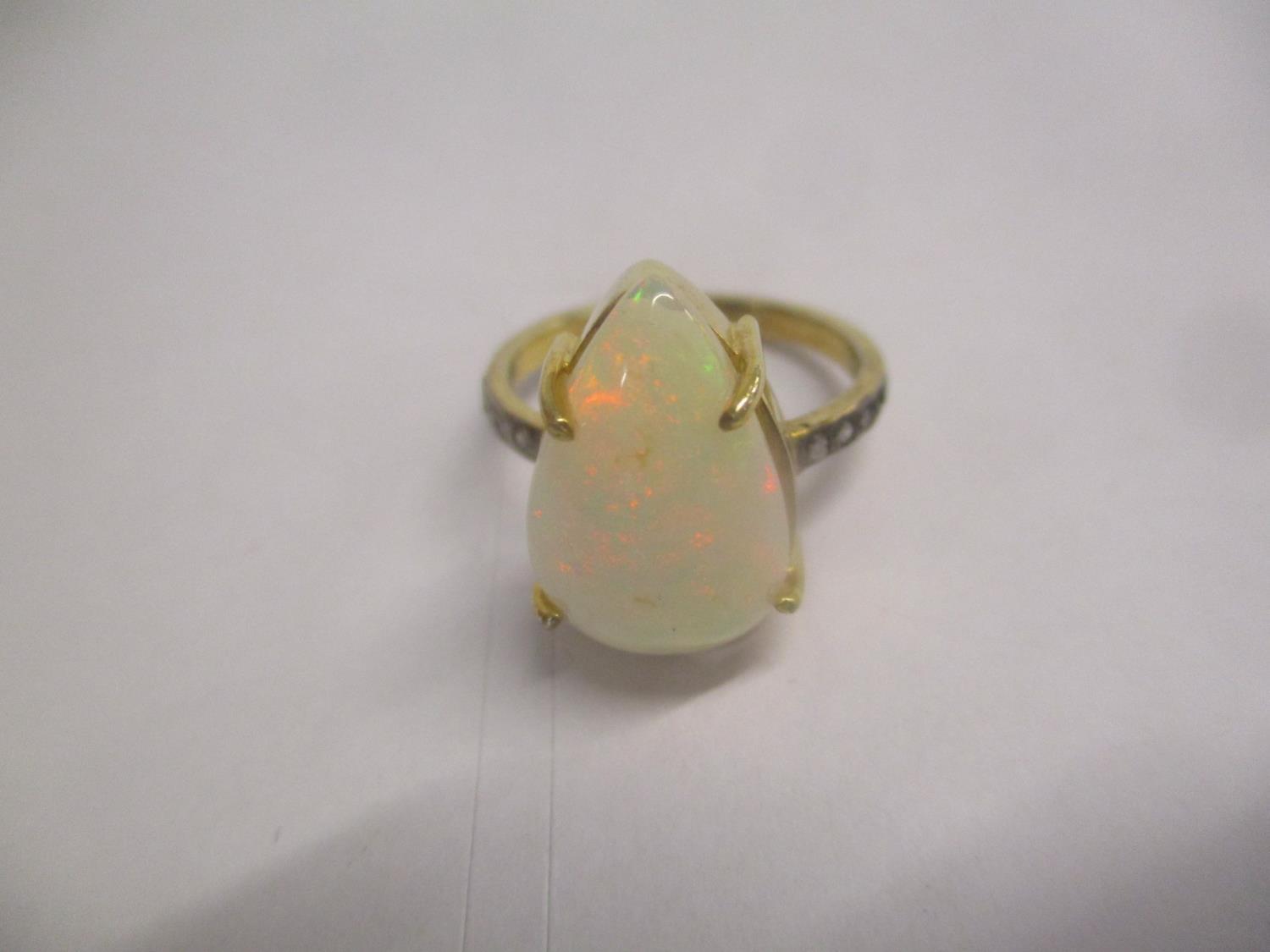 A silver gilt ring set with an opal and diamonds to the shoulders