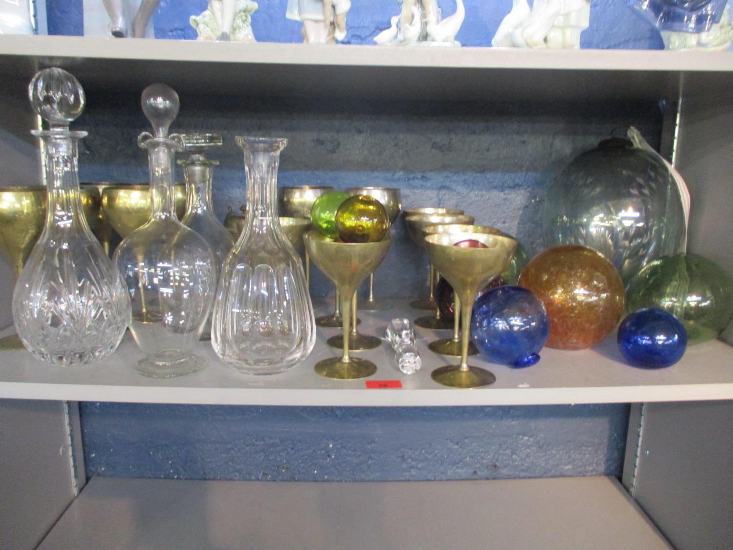 A selection of glass witches balls/sea balls, decanters and stoppers, a French art nouveau enamelled