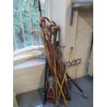 A selection of wooden walking sticks, a shooting stick and other items