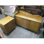 A mid 20th century oak sideboard with twin sliding doors and three short drawers on square tapered