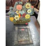 A painted metal fire guard in the form of a basket of flowers and an embossed vintage metal plaque