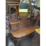 A Victorian mahogany dressing table having a swing mirror flanked by scroll supports and seven short