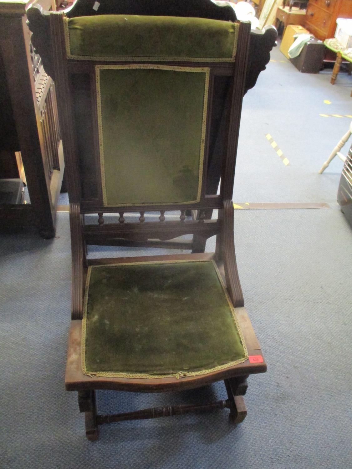 An early 20th century walnut American rocker chair upholstered seat and back in a green fabric,