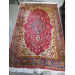 A red ground rug having a central motif and a floral design 206cm h x 125cm w