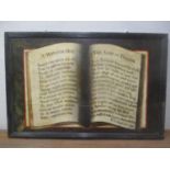 A 19th century painted panel depicting an open book with text, in a moulded frame 92 x 61cm