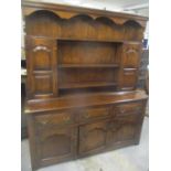 A reproduction oak Georgian inspired dresser having a dental moulded cornice above open shelves