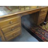 An Ercol twin pedestal desk housing a file drawer and four short drawers together with an Ercol