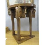 A modern hardwood demi lune hall table supported by three elephant heads and trunks 75" h x 68" w