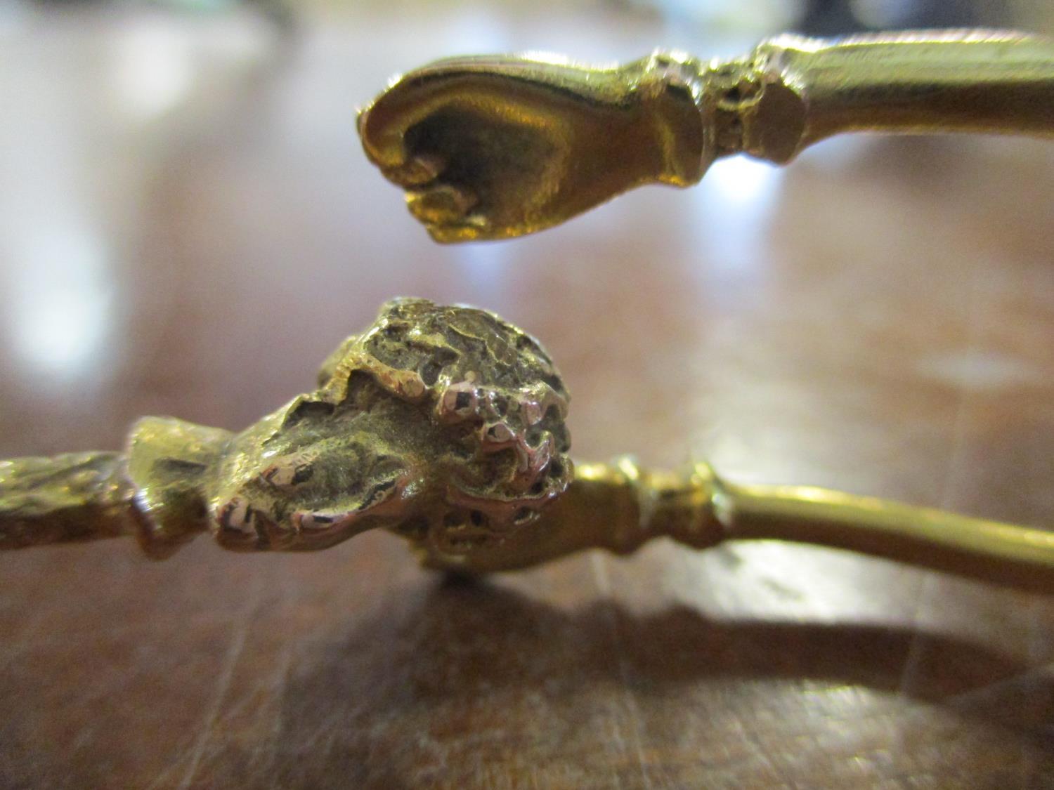 A yellow metal bracelet, the forked and terminating in two clenched fists, the other and terminating - Image 3 of 3