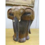 A modern hardwood stool fashioned as four elephants