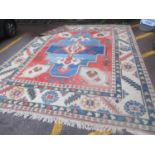 A Turkish hand woven rug having a central motif, geometric designs and tasselled ends 401 x 309cm