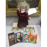 A large vintage doll, tea cards, annuals to include James Bond and other books