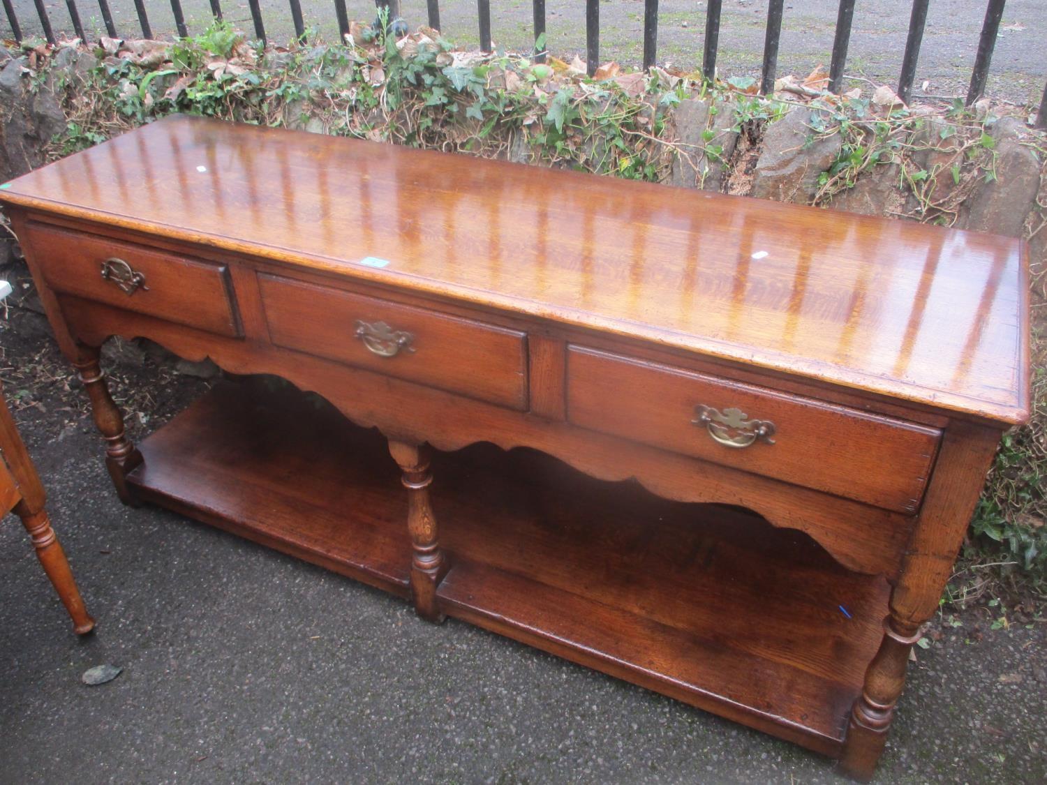 A reproduction oak Titchmarsh & Goodwin dresser base with three drawers and shelf below 76cm h x 168