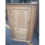 A 19th century large pine corner cabinet with single door and fitted shelves 138cm h x 87cm w